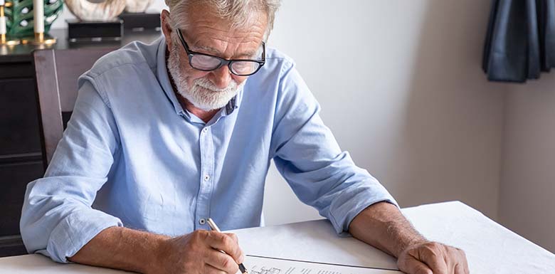 Older man signing documents