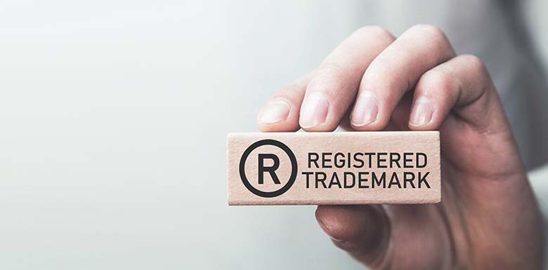 Person holding a wood block with words registered trademarks